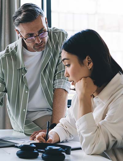 workforce agility, two people sitting in office discussing work seriously overlooking a desk