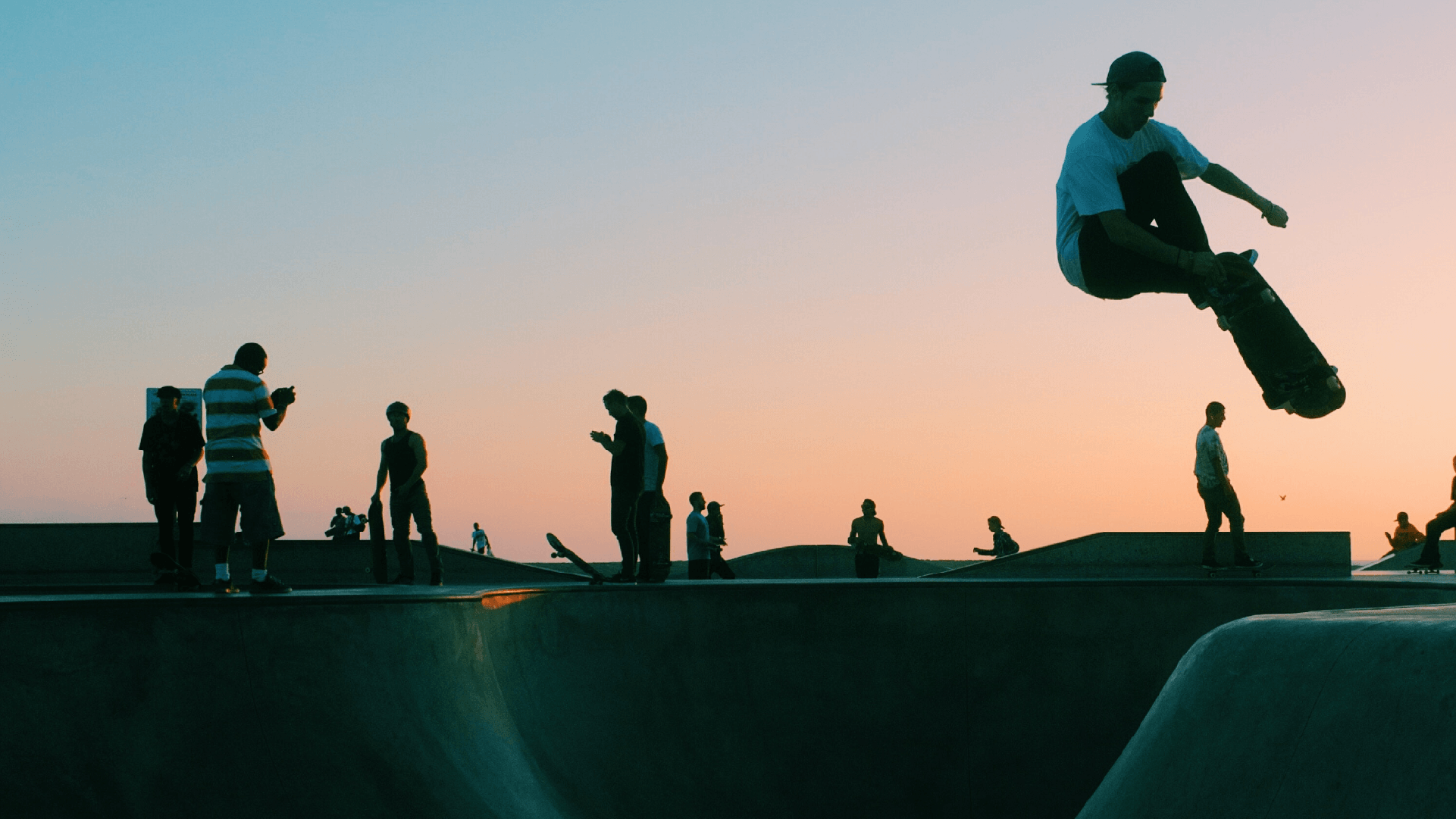 skateboarder jumping out of a bowl at skatepark
