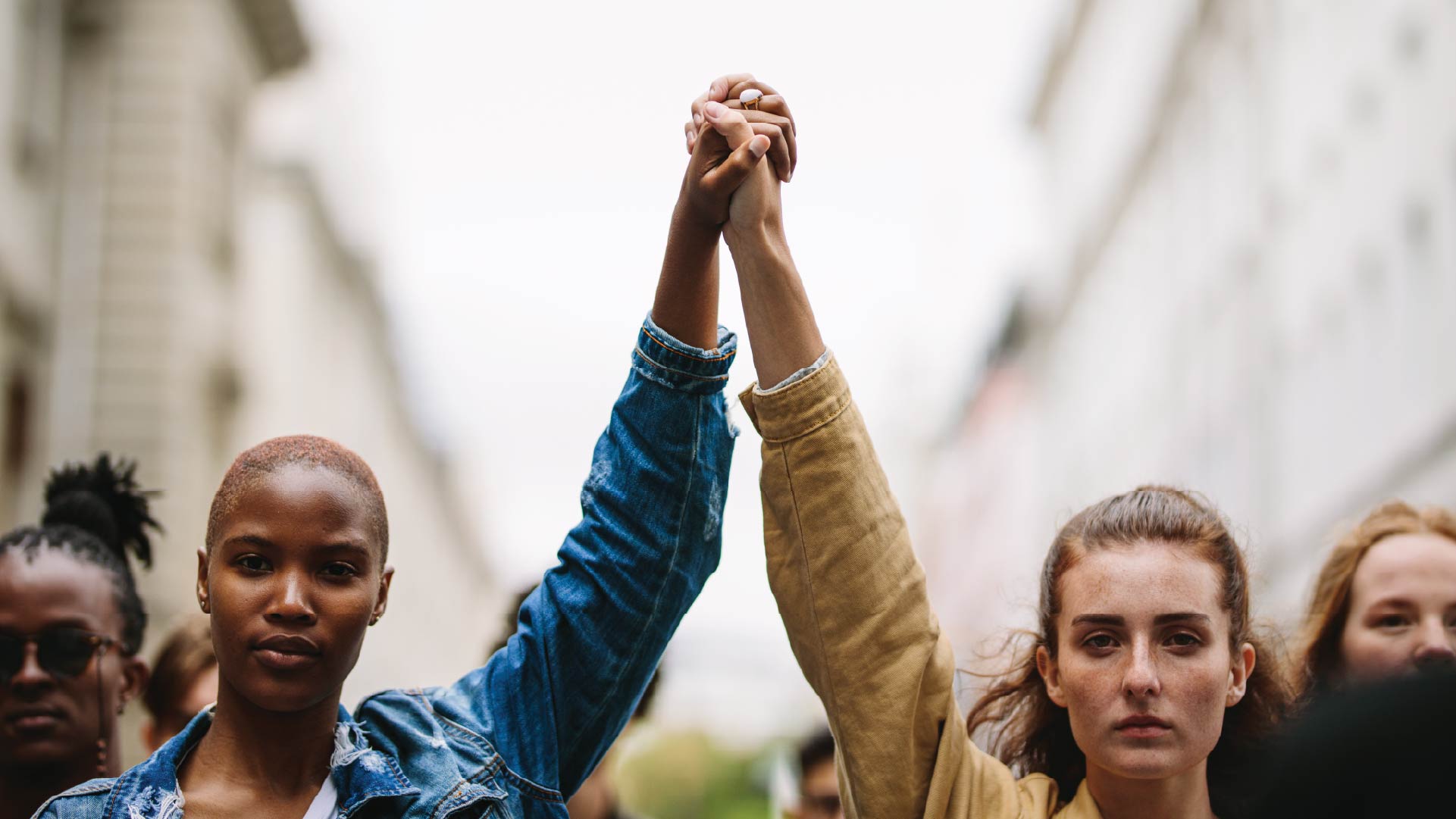 two people holding hands while marching showing the talent revolution