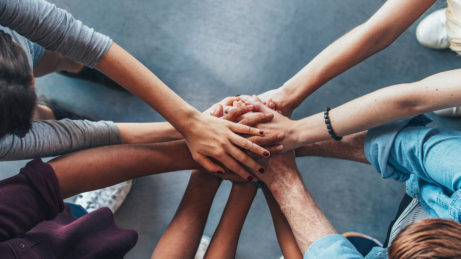 team of people putting their hands together