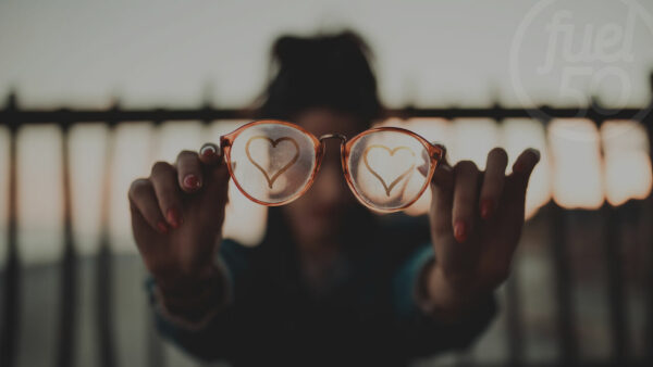 Woman holding glasses with hearts on lenses