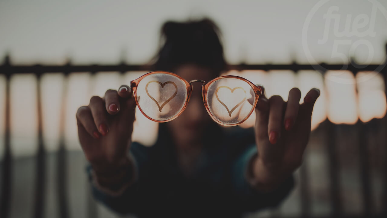 Woman holding glasses with hearts on lenses