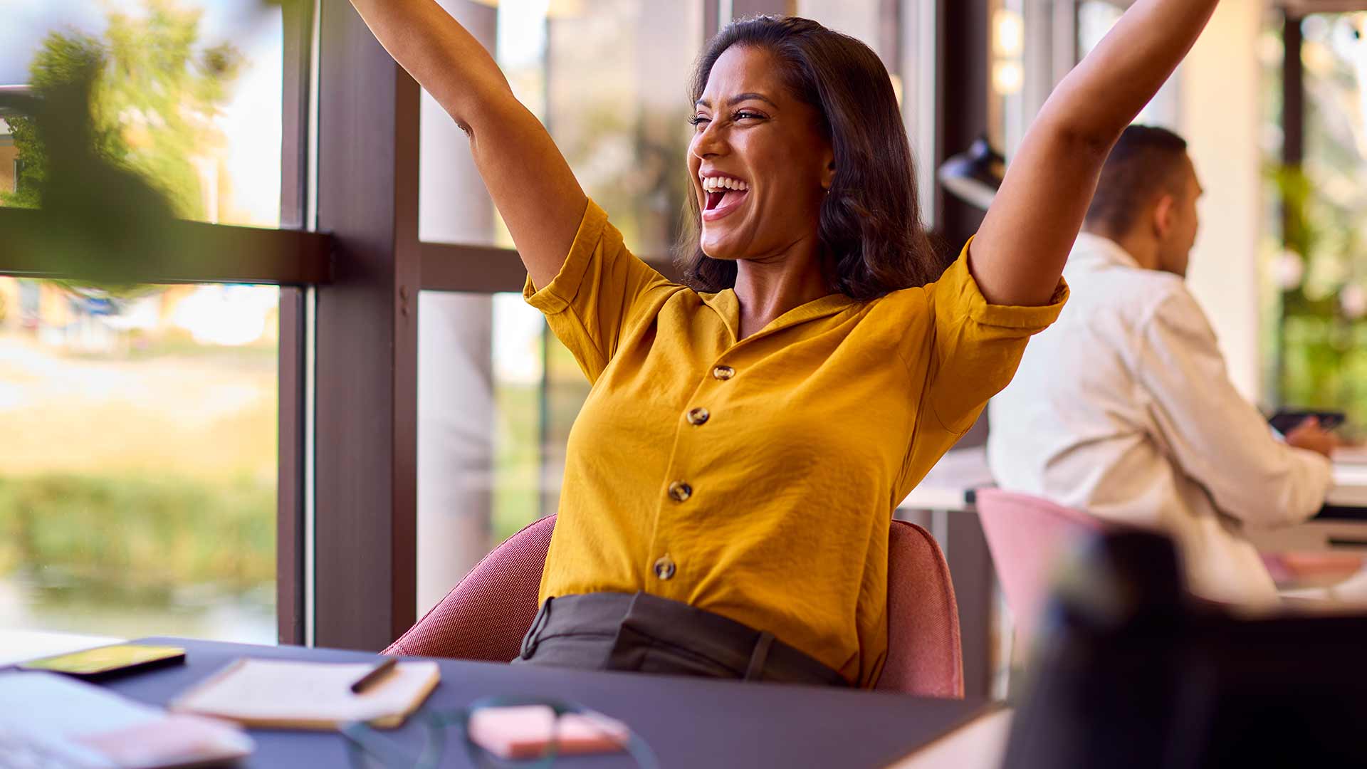 Woman in office excited with hands in the hair, big smile. Excited to benefit from a Skills Ontology at her office.